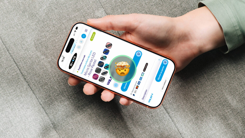 Main tenant un smartphone ouvert sur la fiche produit d’une trottinette Micro Sprite LED rose pastel, avec un émoji tête qui explose au centre de l’écran